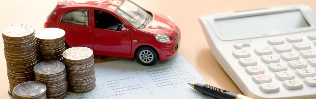Red car model with coins, calculator, and finance documents.