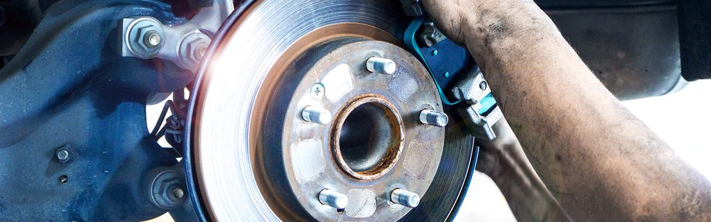 Close-up view of a vehicle brake rotor and caliper during brake repair service.